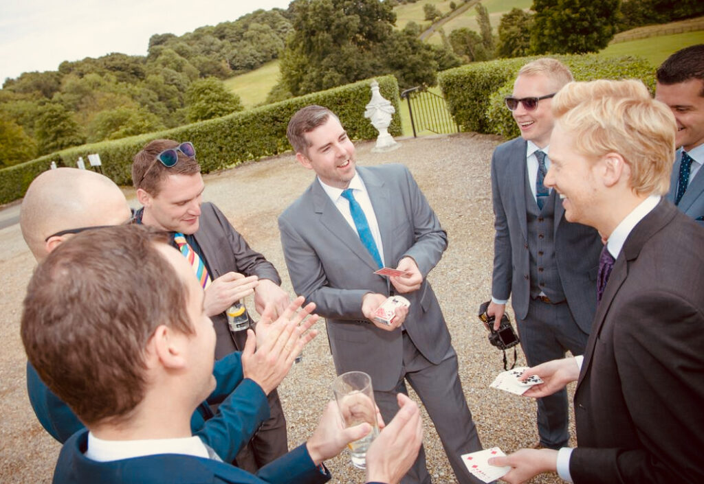 When Should a Magician Perform at Your Wedding? A Timeline That Works 2 Wedding magician performing close-up magic for guests at an outdoor drinks reception